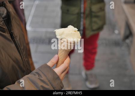 Kinderhände mit Vanilleeis in Waffelform. Stockfoto