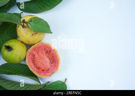 Frische rote Guave mit grünen Blättern auf weißem Hintergrund Stockfoto