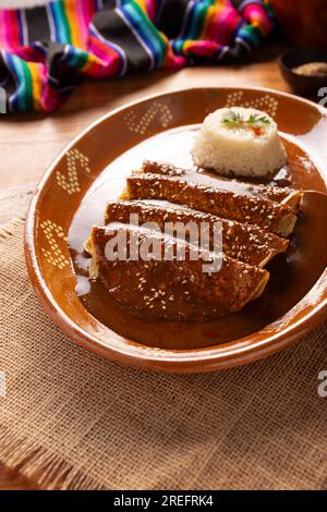 Hühnerenmoladas. Auch bekannt als Mole poblano enchiladas, sind sie ein typisches mexikanisches Gericht, das in Mexiko und dem Rest der Welt sehr beliebt ist. Stockfoto