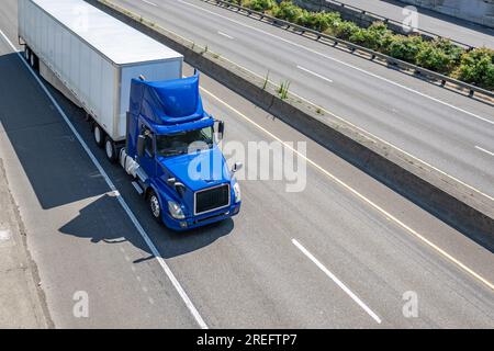 Blaues Day Cab in Industriequalität vor Ort liefert Sattelzugmaschine mit Dachspoiler für den Transport von gewerblicher Fracht in einem Sattelanhänger Stockfoto
