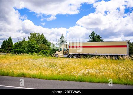 Beige für Industrieanwendungen, Nahverkehrsfahrerhaus, Großfahrzeug, lokale Auslieferungen, Sattelzugmaschine mit Dachspoiler, Transport von gewerblicher Fracht in Trockenwagen, Sattelanhänger dri Stockfoto