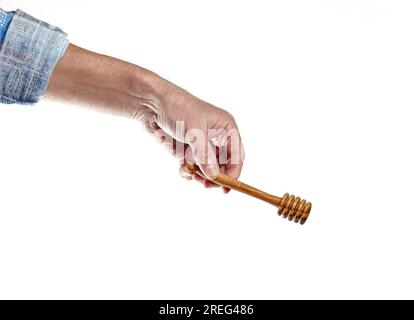 Männerhand mit Holzhonigstäbchen isoliert auf weißem Hintergrund. Honigstifter, Platz für Text Stockfoto