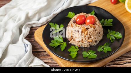 Mandelreis. Türkische Köstlichkeiten. Reis mit schwarzem Pfeffer, Zimt, Nelkenpfeffer, Johannisbeeren, Mandeln und Reis. Ramadan-Essen. Lokaler Name: Ic pila Stockfoto