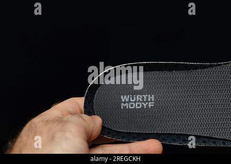 Hamburg, Deutschland - 16. Februar 2022: Männliche Hand hält neuen Würth Modyf Schutzschuh Innensohle schwarzer Hintergrund - sichtbares Logo-Logo Stockfoto