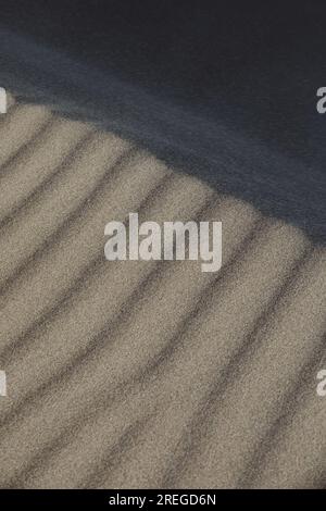 Nahaufnahme von Schatten und Linien in braungfarbenem Sand Stockfoto