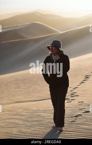 In der Wüste über eine Frau in einer hellen, runden, reflektierenden Sonnenbrille nachzudenken Stockfoto