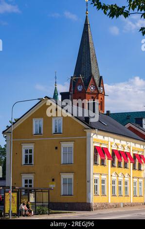 Straßenszene mit Blick auf den Kirchturm von Sankt Petri Kyrka, die Kirche St. Peter in der historischen Innenstadt von Västervik, Kalmar län, Schweden. Stockfoto