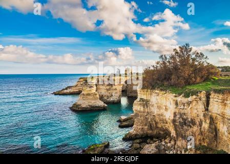 Torre Sant'Andrea Felsformationen und der Leuchtturm Missipezza in der Ferne Stockfoto