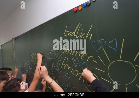 Kaufbeuren, Deutschland. 28. Juli 2023. Schüler der Klasse 4b einer Grund- und Mittelschule bemalen ihre Tafel mit sommerlichen Motiven während der letzten Stunde vor den Sommerferien. Kredit: Karl-Josef Hildenbrand/dpa/Alamy Live News Stockfoto