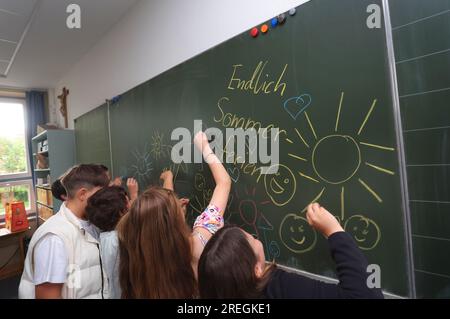 Kaufbeuren, Deutschland. 28. Juli 2023. Schüler der Klasse 4b einer Grund- und Mittelschule bemalen ihre Tafel mit sommerlichen Motiven während der letzten Stunde vor den Sommerferien. Kredit: Karl-Josef Hildenbrand/dpa/Alamy Live News Stockfoto