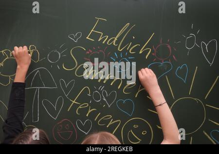 Kaufbeuren, Deutschland. 28. Juli 2023. Schüler der Klasse 4b einer Grund- und Mittelschule bemalen ihre Tafel mit sommerlichen Motiven während der letzten Stunde vor den Sommerferien. Kredit: Karl-Josef Hildenbrand/dpa/Alamy Live News Stockfoto