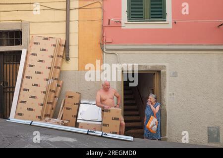 Cinque Terre, Italien - Seniorenpaar plaudert gerne vor der offenen Tür der Via Colombo in Riomaggiore, einer Küstenstadt an der italienischen Riviera. Stockfoto