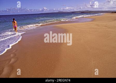 Ein Tourist spaziert entlang des wunderschönen unberührten Papohaku Beach, West Molokai, einem der längsten und schönsten Strände auf den hawaiianischen Inseln. Stockfoto