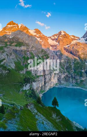 Der Sonnenuntergang auf dem Oeschinensee aus der Vogelperspektive. Kandersteg, Berner Oberland, Frutigen-Niedersimmental, Kanton Bern, Schweiz. Stockfoto