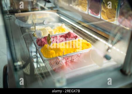 Eissorten werden in Metallschalen zum Verkauf angeboten Stockfoto