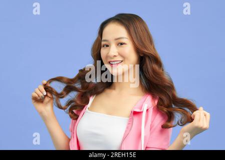 Porträt einer jungen lächelnden Frau, die wunderschön und selbstbewusst aussieht Stockfoto