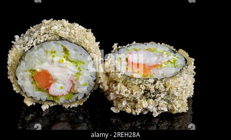 Warmes Sushi-Brötchen mit Lachs, Frischkäse, Krabben und fliegendem Fischrogen auf einem schwarzen Spiegel Stockfoto