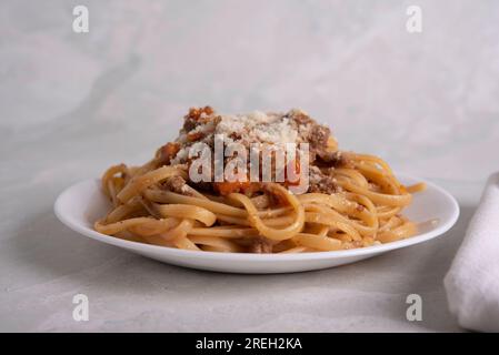 Weißer Teller mit Pasta alla Bolognese mit Fleischsauce, Käse und Gemüse Stockfoto