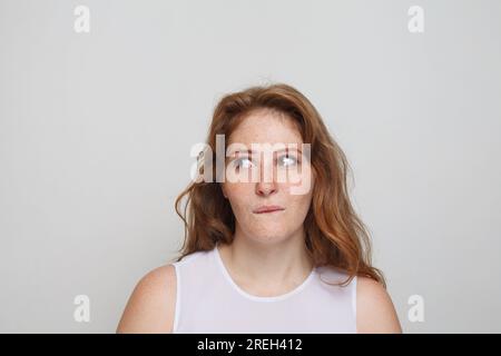 Denkende Frau auf weißem Hintergrund. Zweifel- und Ideenkonzept Stockfoto