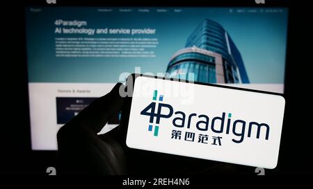 Person, die ein Smartphone mit dem Logo des KI-Unternehmens 4. Paradigm Technology Co. Ltd. Auf dem Bildschirm vor der Website hält. Konzentrieren Sie sich auf das Display des Telefons. Stockfoto