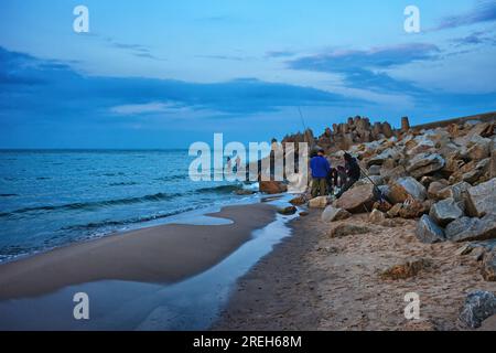 Der Ostseestrand endet mit Anglern in den Felsen des Wellenbrechers in der Stadt Wladyslawowo in Polen. Stockfoto