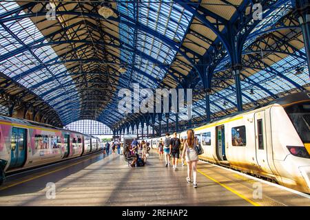 Leute, die am Bahnsteig in Brighton Station, Brighton, East Sussex, England entlang laufen Stockfoto