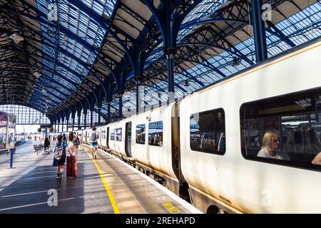 Leute, die am Bahnsteig in Brighton Station, Brighton, East Sussex, England entlang laufen Stockfoto