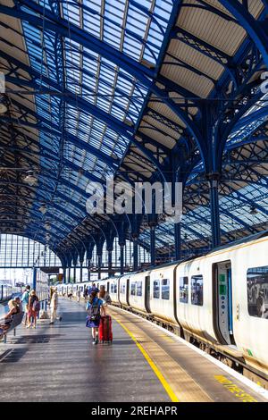 Leute, die am Bahnsteig in Brighton Station, Brighton, East Sussex, England entlang laufen Stockfoto