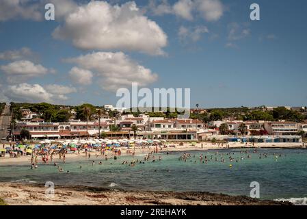 Urlauber kühlen sich am Strand von Punta Prima in Sant Lluis, Süd-Menorca, Balearen ab. Stockfoto
