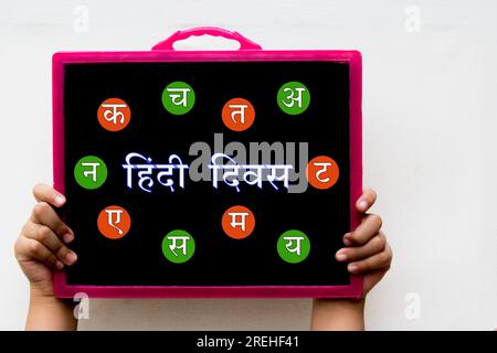 Hindi Diwas bedeutet Wort oder Text des Hindi Language Day, der auf schwarzer Tafel mit der Hand auf weißem Hintergrund geschrieben ist. Stockfoto