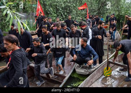 Srinagar, Indien. 28. Juli 2023. Schiitische Muslime kommen auf Booten an, während sie an einer Ashura-Prozession auf Booten teilnehmen. Muharram ist der erste Monat des Islam. Es ist einer der heiligsten Monate im islamischen Kalender. Schiitische Moslems gedenken Muharram als einen Monat der Trauer zum Gedenken an den Enkel des Märtyrers Islamischer Prophet Muhammad, Imam Hussain, der auf Ashura (10. Tag Muharram) in der Schlacht von Karbala im Jahr 680 n. Chr. martyriert wurde Kredit: SOPA Images Limited/Alamy Live News Stockfoto
