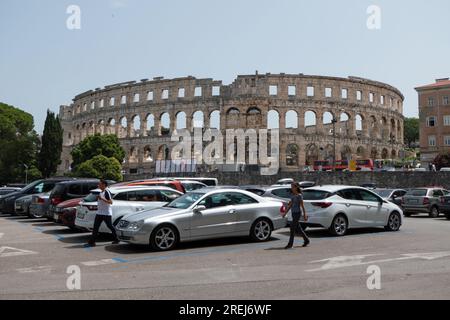 Blick auf Pula (Pola) in Kroatien mit Menschen und Wahrzeichen: Pula Arena, ein römisches Amphitheater. Tourismus und Reisen in kroatischer Stadt im Sommer, mit mon Stockfoto