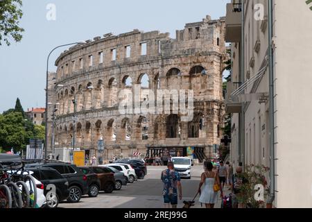 Blick auf Pula (Pola) in Kroatien mit Menschen und Wahrzeichen: Pula Arena, ein römisches Amphitheater. Tourismus und Reisen in kroatischer Stadt im Sommer, mit mon Stockfoto