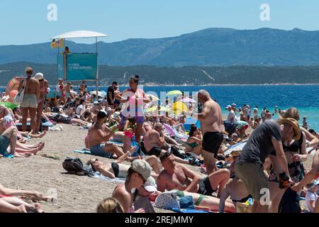 Blick auf Zlatni Rat (Goldenes Horn oder Goldenes Kap), überfüllter Strand auf Brac Island in Kroatien, mit Menschen schwimmen. Touristen, die Sommerreisen genießen Stockfoto