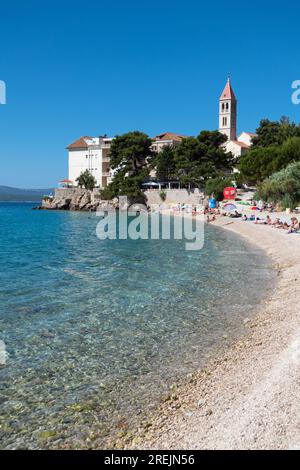 Blick auf den Martinica-Strand in der Nähe von Bol auf Brac Island in Kroatien, mit Menschen zum Sonnenbaden und Schwimmen. Kristallklares blaues Wasser der Adria Stockfoto