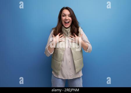 Positive junge brünette Dame, die freundlich posiert und lächelt Stockfoto