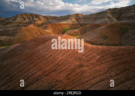 Bei Sonnenaufgang werden diese erodierten Muster von Schlamm auf den Hügeln unterhalb des Conata Basin im Badlands-Nationalpark in South Dakota enthüllt. Stockfoto