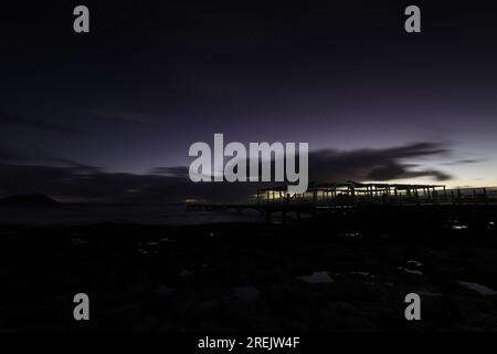 Lange Exposition über einem Lava-Strand. Steiniger Sandstrand am Morgen. bucht, Küste bei Corralejo, Provinz Las Palmas, Spanien Stockfoto