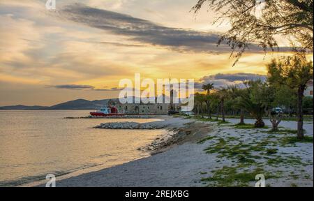 Die Küste von Kastel Gomilica in Kastela, Kroatien in der Dämmerung. Kastilac, ein Festungsdorf aus dem 16. Jahrhundert, liegt im Zentrum. Das Äußere wurde als Gam benutzt Stockfoto