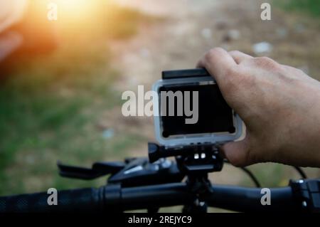 Männliche Handjustierkamera auf dem Fahrrad Stockfoto