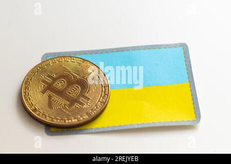 Bitcoin-Symbol auf ukrainischer Flagge 3D Hintergrund. Krypto-Währungs-Hintergrund für virtuelles Geld und Wertspeicher. Konzept der politischen Regulierung in Stockfoto