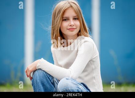 Süße Preteen Gitl mit blondem Haar Porträt. Hübsches Kindermodel, das in die Kamera schaut Stockfoto