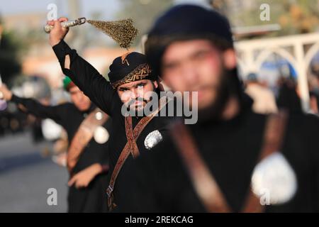 Bagdad, Irak. 28. Juli 2023. Schiitische Moslems schlugen sich während einer rituellen Zeremonie am Tag von Ashura in Kadhimiya mit Ketten. Ashura ist der zehnte Tag von Muharram, dem ersten Monat im islamischen Kalender, der den Tag markiert, an dem Husayn ibn Ali, der Enkel des islamischen Propheten Muhammad, in der Schlacht von Karbala getötet wurde. Kredit: Ameer Al-Mohammedawi/dpa/Alamy Live News Stockfoto