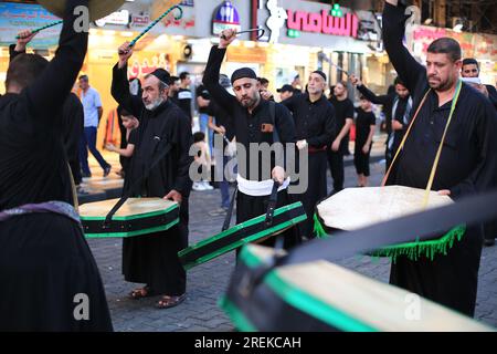 Bagdad, Irak. 28. Juli 2023. Schiitische Moslems schlugen sich während einer rituellen Zeremonie am Tag von Ashura in Kadhimiya mit Ketten. Ashura ist der zehnte Tag von Muharram, dem ersten Monat im islamischen Kalender, der den Tag markiert, an dem Husayn ibn Ali, der Enkel des islamischen Propheten Muhammad, in der Schlacht von Karbala getötet wurde. Kredit: Ameer Al-Mohammedawi/dpa/Alamy Live News Stockfoto