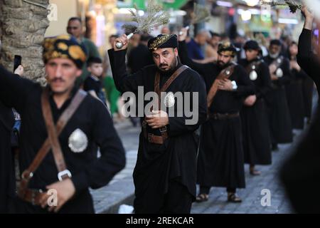 Bagdad, Irak. 28. Juli 2023. Schiitische Moslems schlugen sich während einer rituellen Zeremonie am Tag von Ashura in Kadhimiya mit Ketten. Ashura ist der zehnte Tag von Muharram, dem ersten Monat im islamischen Kalender, der den Tag markiert, an dem Husayn ibn Ali, der Enkel des islamischen Propheten Muhammad, in der Schlacht von Karbala getötet wurde. Kredit: Ameer Al-Mohammedawi/dpa/Alamy Live News Stockfoto