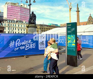 Glasgow, Schottland, Vereinigtes Königreich 28. Juli 2023. Die Logos und Paraphenelien der UCI-Radweltmeisterschaft erscheinen im zentralen Zentrum des george Square, wo die Einheimischen die Spannung spüren, ohne die anstehenden Verkehrsprobleme zu bemerken. Credit Gerard Ferry/Alamy Live News Stockfoto