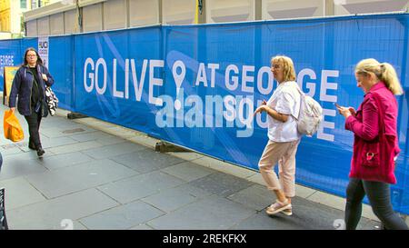 Glasgow, Schottland, Vereinigtes Königreich 28. Juli 2023. Die Logos und Paraphenelien der UCI-Radweltmeisterschaft erscheinen im zentralen Zentrum des george Square, wo die Einheimischen die Spannung spüren, ohne die anstehenden Verkehrsprobleme zu bemerken. Credit Gerard Ferry/Alamy Live News Stockfoto