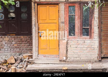 Rainawari, Srinagar, Jammu und Kaschmir, Indien. Gelbe Tür in einem Backsteinhaus in Srinagar. Stockfoto