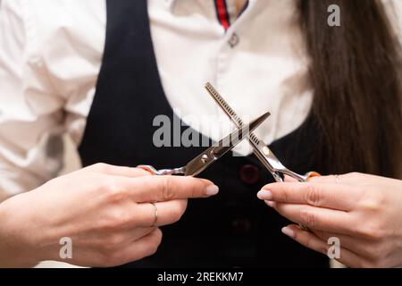 Die Handwerkerin hält eine Friseurschere in den Händen Stockfoto