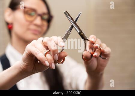 Der Friseurmeister hält eine Friseurschere in den Händen Stockfoto